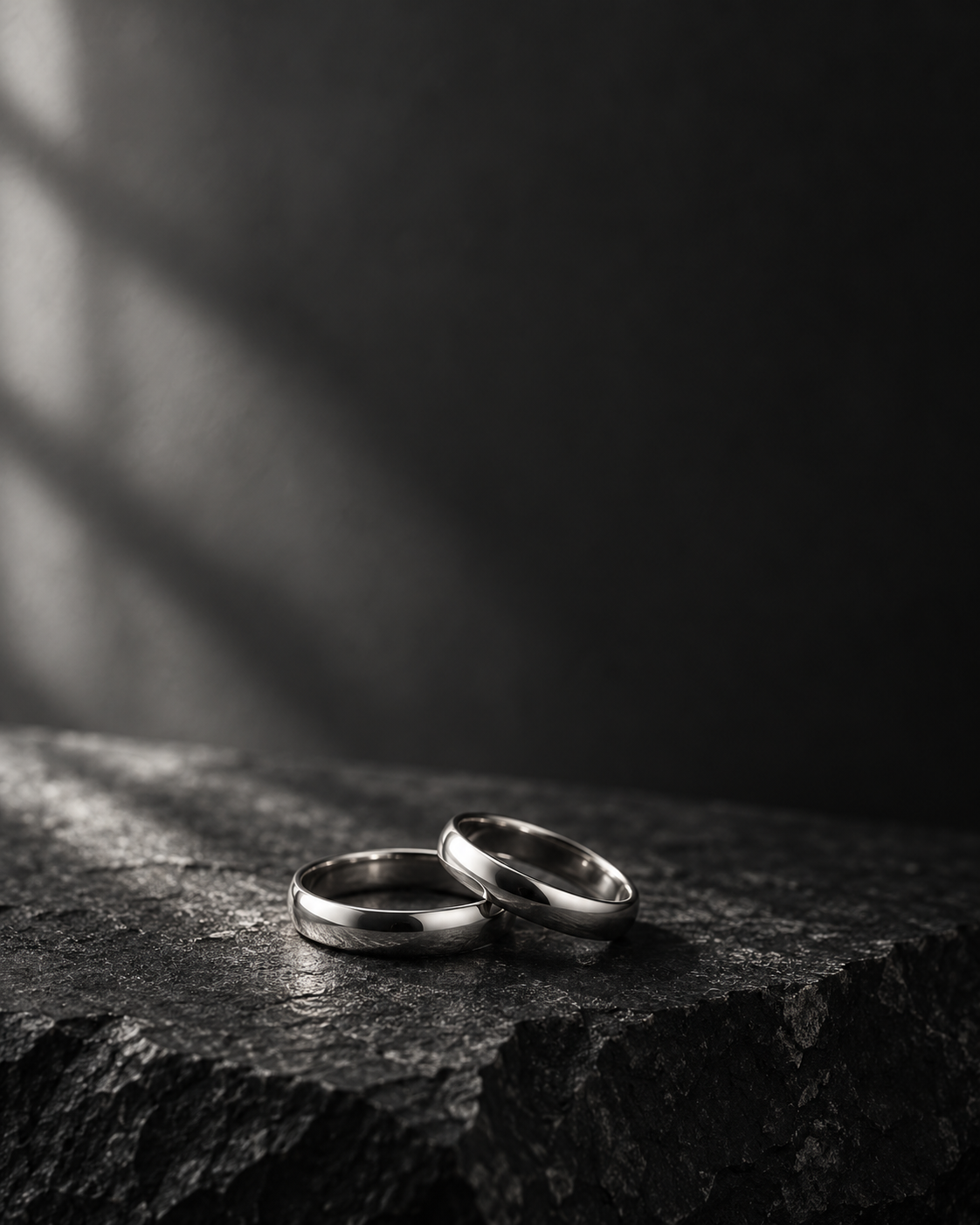 Dos anillos de boda sobre una superficie oscura